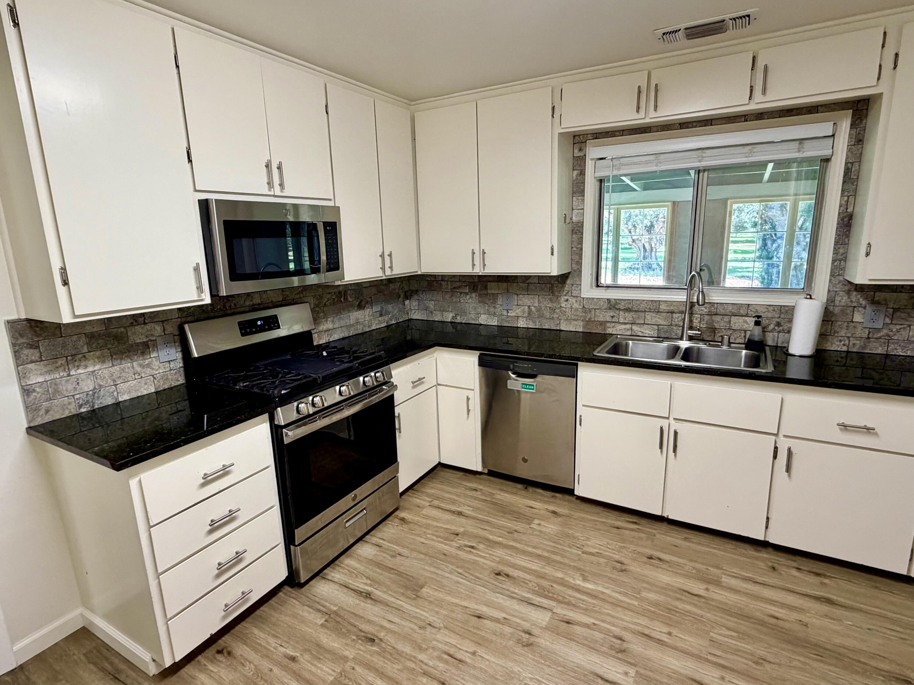 5572 Olive Street Anderson, CA 96007 - Photo 10 of 35 a white kitchen with granite countertop stainless steel appliances