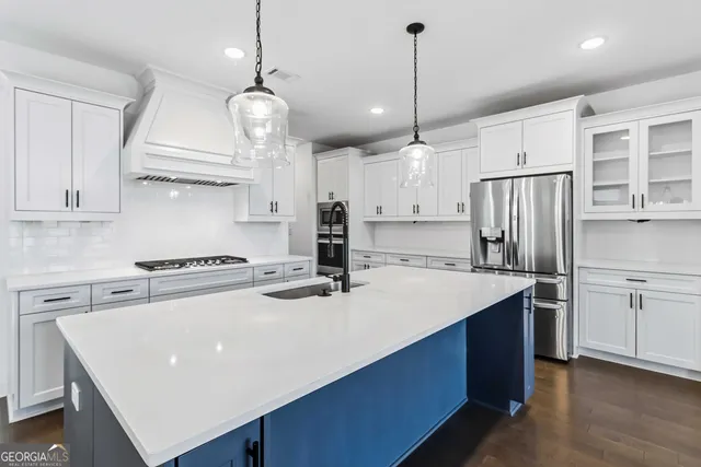 a kitchen with a stove a refrigerator a sink and dishwasher with wooden floor