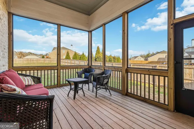 a balcony with wooden floor table and chairs