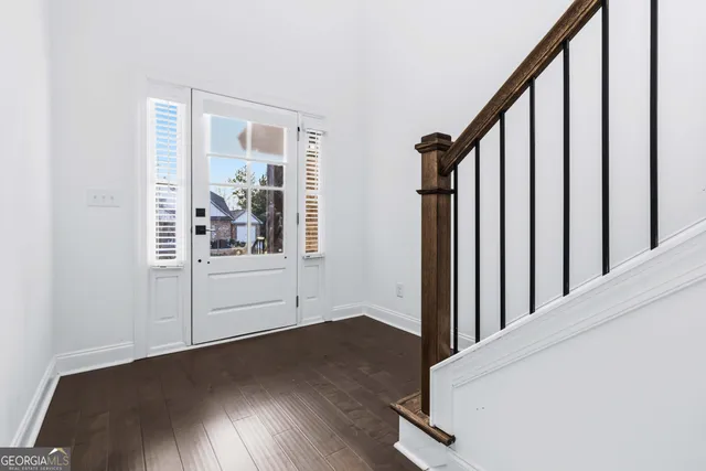 a view of a hallway with wooden floor and staircase