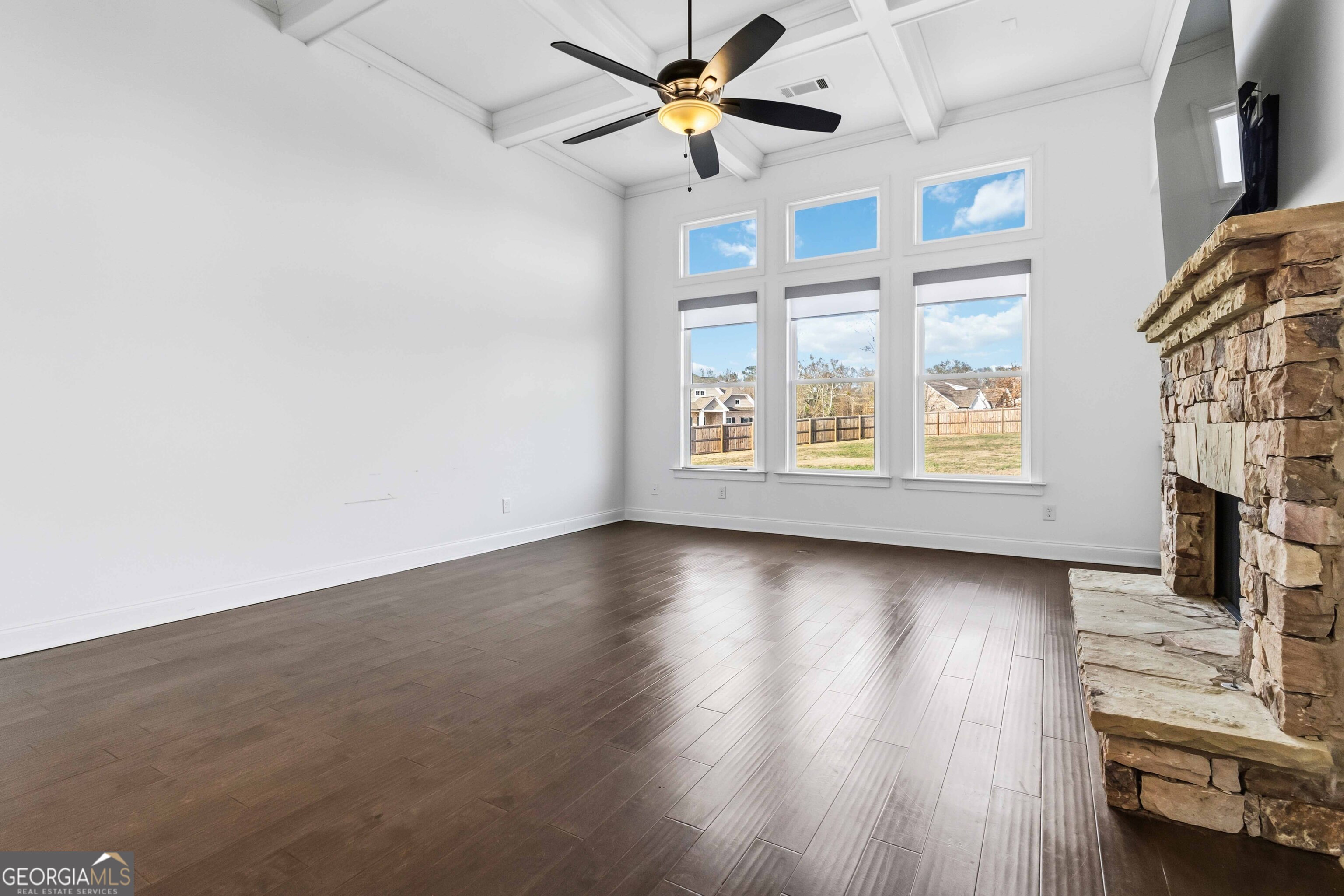 2950 Stone Road Watkinsville, GA 30677 - Photo 10 of 53 an empty room with wooden floor chandelier fan and windows