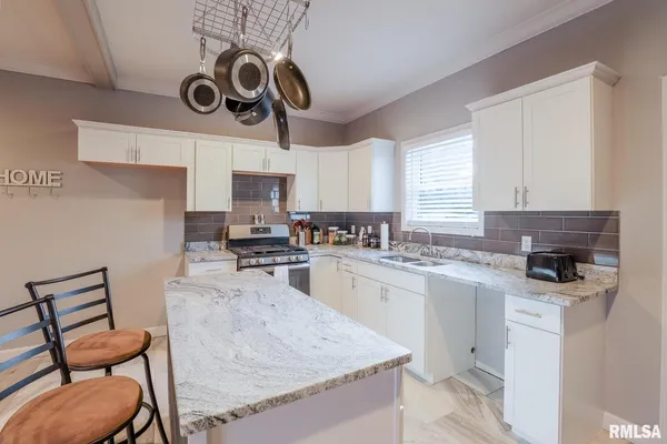 a kitchen with a stove cabinets and chairs