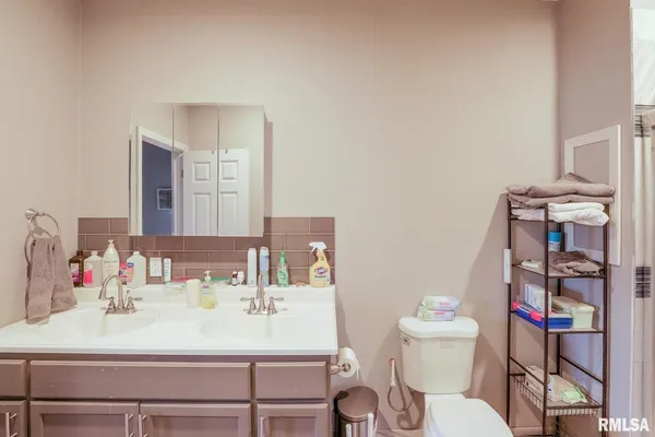 a bathroom with a sink vanity mirror and toilet