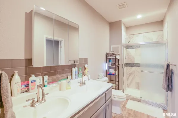 a bathroom with a sink vanity mirror and toilet