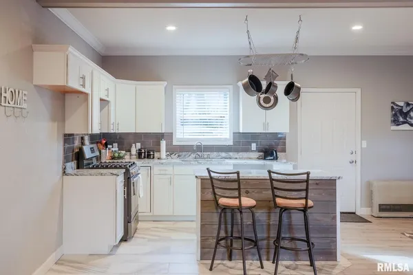a kitchen with a stove a sink and cabinets