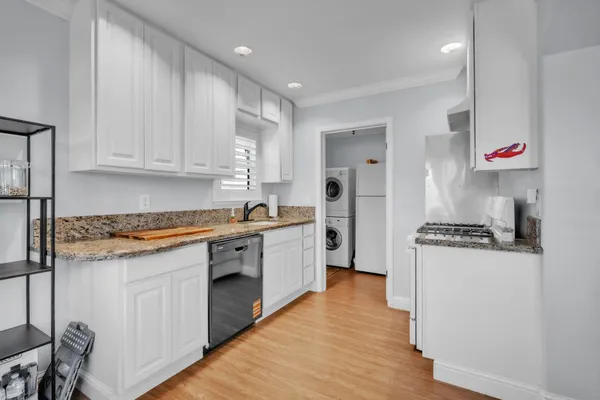 a kitchen with granite countertop a sink and a stove top oven