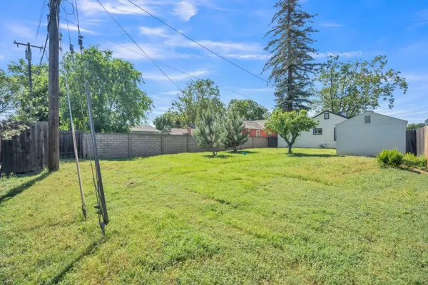 a view of backyard with swimming pool and seating space