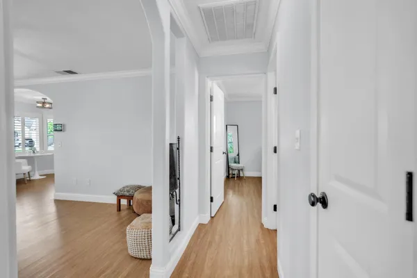 a view of a hallway with wooden floor and closet