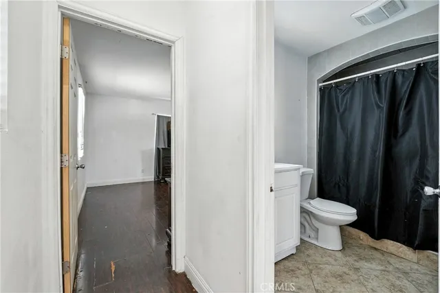 a bathroom with a granite countertop sink vanity mirror and toilet