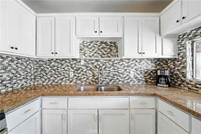 a kitchen with a refrigerator and white cabinets