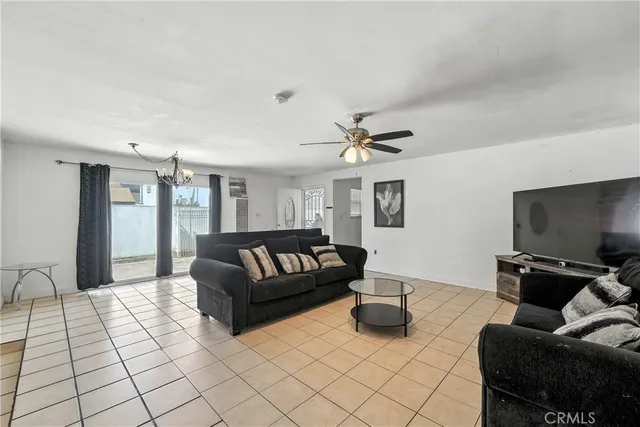 a living room with furniture and a flat screen tv with kitchen view