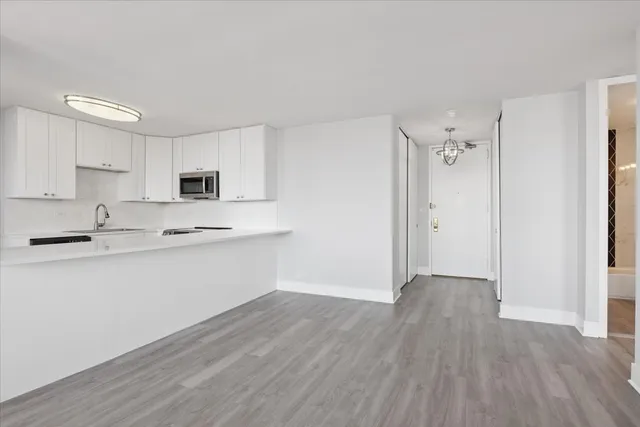 a kitchen with granite countertop white cabinets and stainless steel appliances
