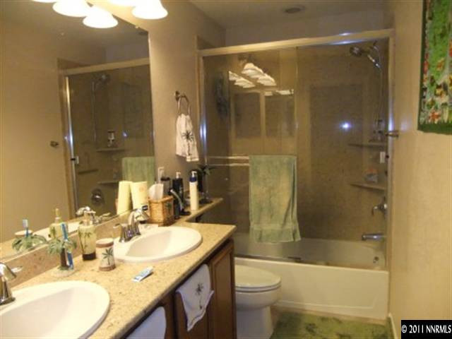 8967 Grisom Way Reno, NV 89506 - Photo 8 of 12 a bathroom with a granite countertop sink a toilet and shower