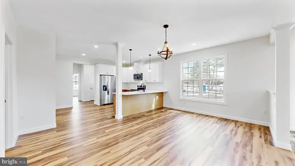 a kitchen with a sink window and wooden floor