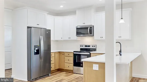 a kitchen with granite countertop a stove a sink and a refrigerator
