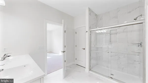 a view of kitchen and empty room with wooden floor