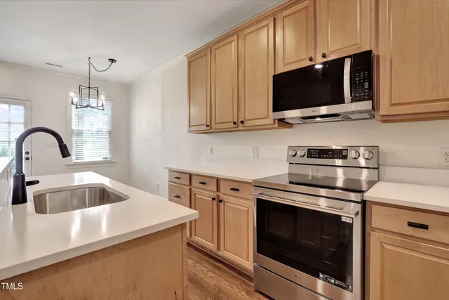a kitchen with stainless steel appliances a sink and a refrigerator