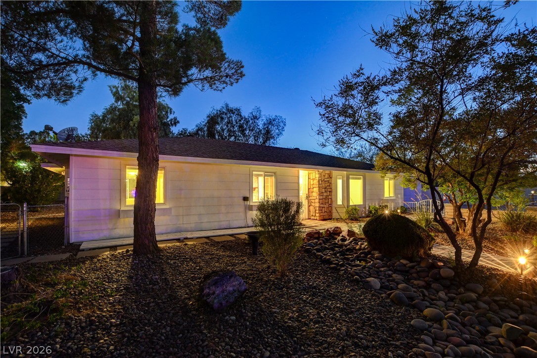 7631 Bermuda Road Las Vegas, NV 89123 - Photo 56 of 64 An inviting exterior with illuminated windows beckons from a beautifully landscaped yard at twilight.