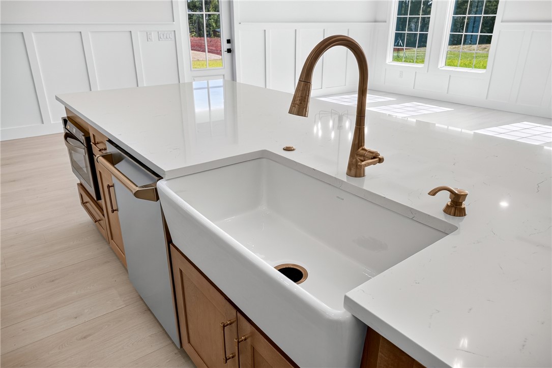 414 Blume Road Anderson, SC 29625 - Photo 27 of 50 An expansive kitchen island features elegant stone countertops and a classic farmhouse sink.