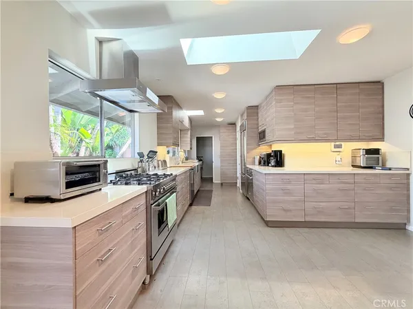 a large kitchen with stainless steel appliances lots of counter space and a sink