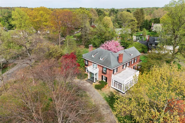 a aerial view of a house with large trees and plants