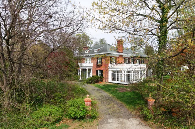 an aerial view of a house with a yard and large trees