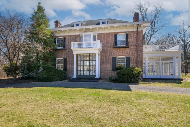 a view of an empty room with wooden floor fridge and a window