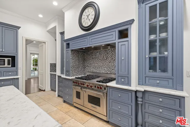 a large kitchen with stainless steel appliances granite countertop a sink and dishwasher with wooden cabinets