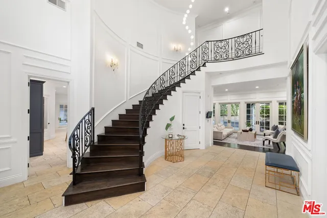 a living room with furniture fireplace and large windows