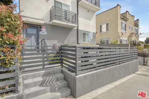 a view of a house with barbeque and outdoor seating