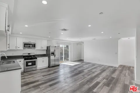 a view of kitchen with stainless steel appliances refrigerator stove microwave and cabinets