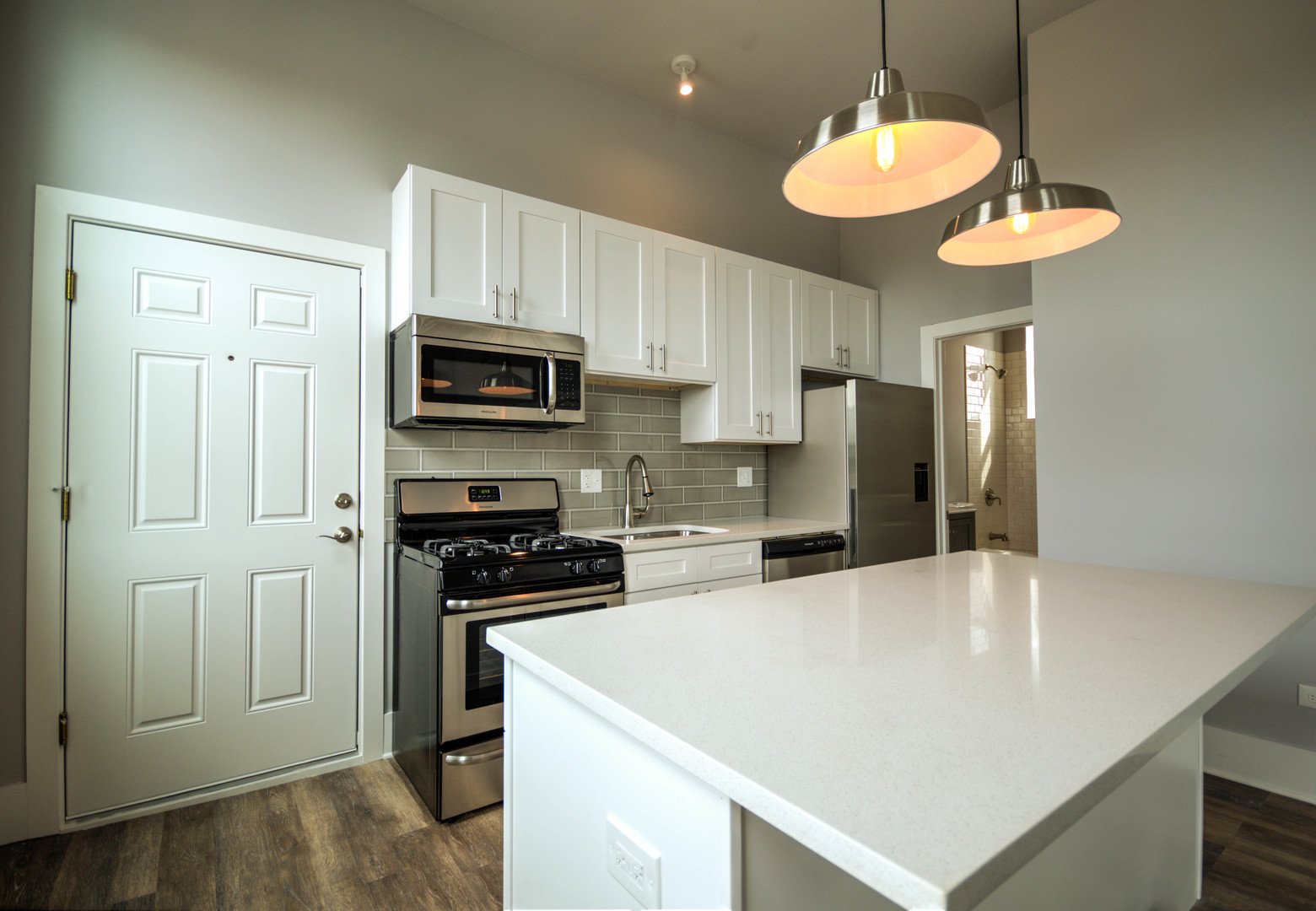 2115 South Wood Street, Unit 2S Chicago, IL 60608 - Photo 3 of 9 a kitchen with kitchen island a counter space a sink and stainless steel appliances