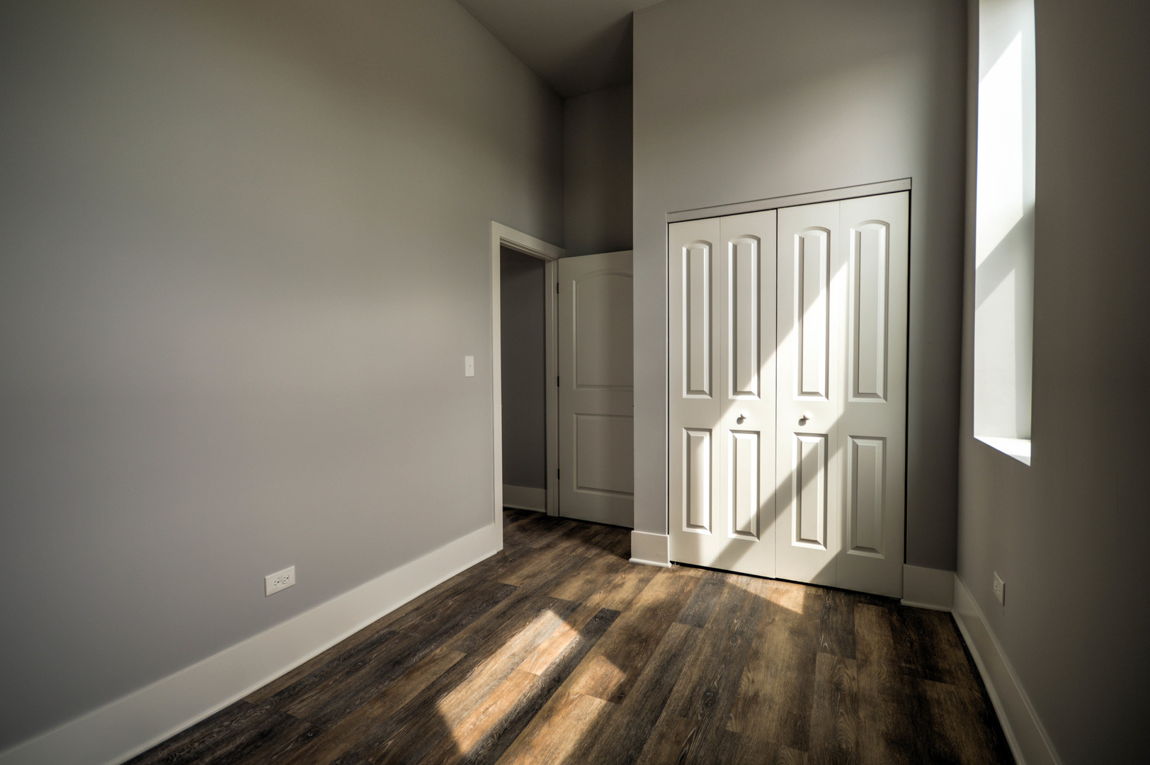 2115 South Wood Street, Unit 2S Chicago, IL 60608 - Photo 7 of 9 an empty room with wooden floor and windows