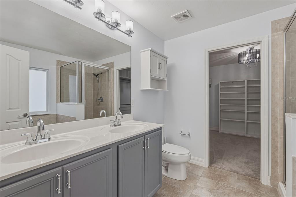 25134 Palisade Road Punta Gorda, FL 33983 - Photo 44 of 58 a bathroom with a double vanity sink a toilet and a shower
