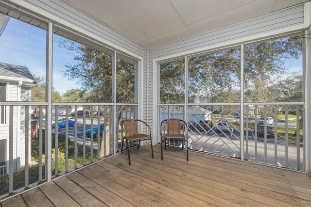 a view of a balcony with chairs and wooden floor