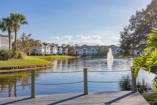 a dining room with wooden floor a chandelier a glass table and chairs