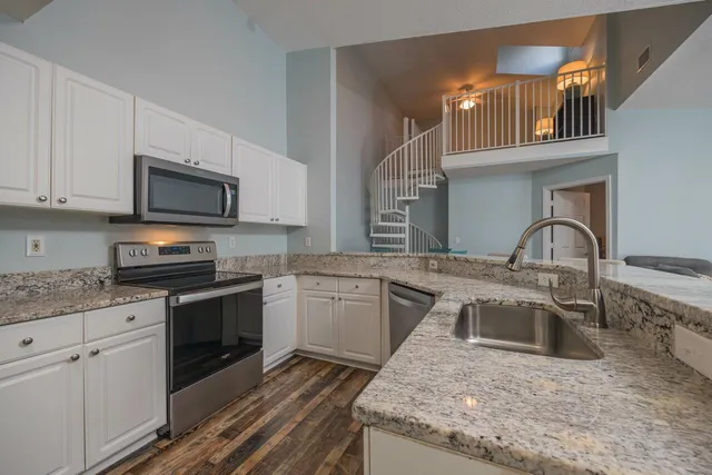 a kitchen with stainless steel appliances granite countertop a sink stove and microwave