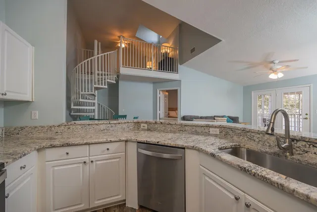 a kitchen with granite countertop a sink and cabinets