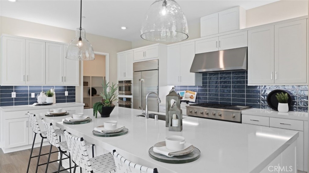a kitchen with stainless steel appliances kitchen island granite countertop a sink a stove and a dining table
