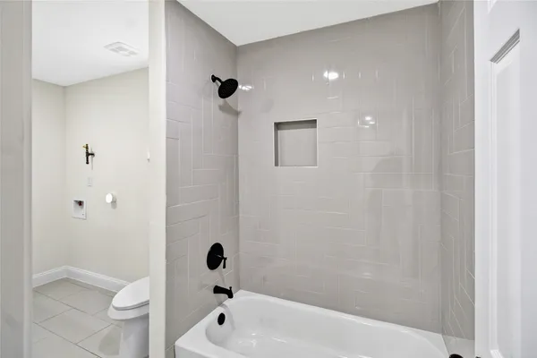 a bathroom with a shower a toilet and a bathtub
