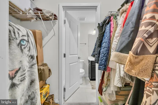 a view of walk in closet with clothes and shoes