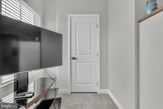 a view of a hallway with wooden floor and a bathroom
