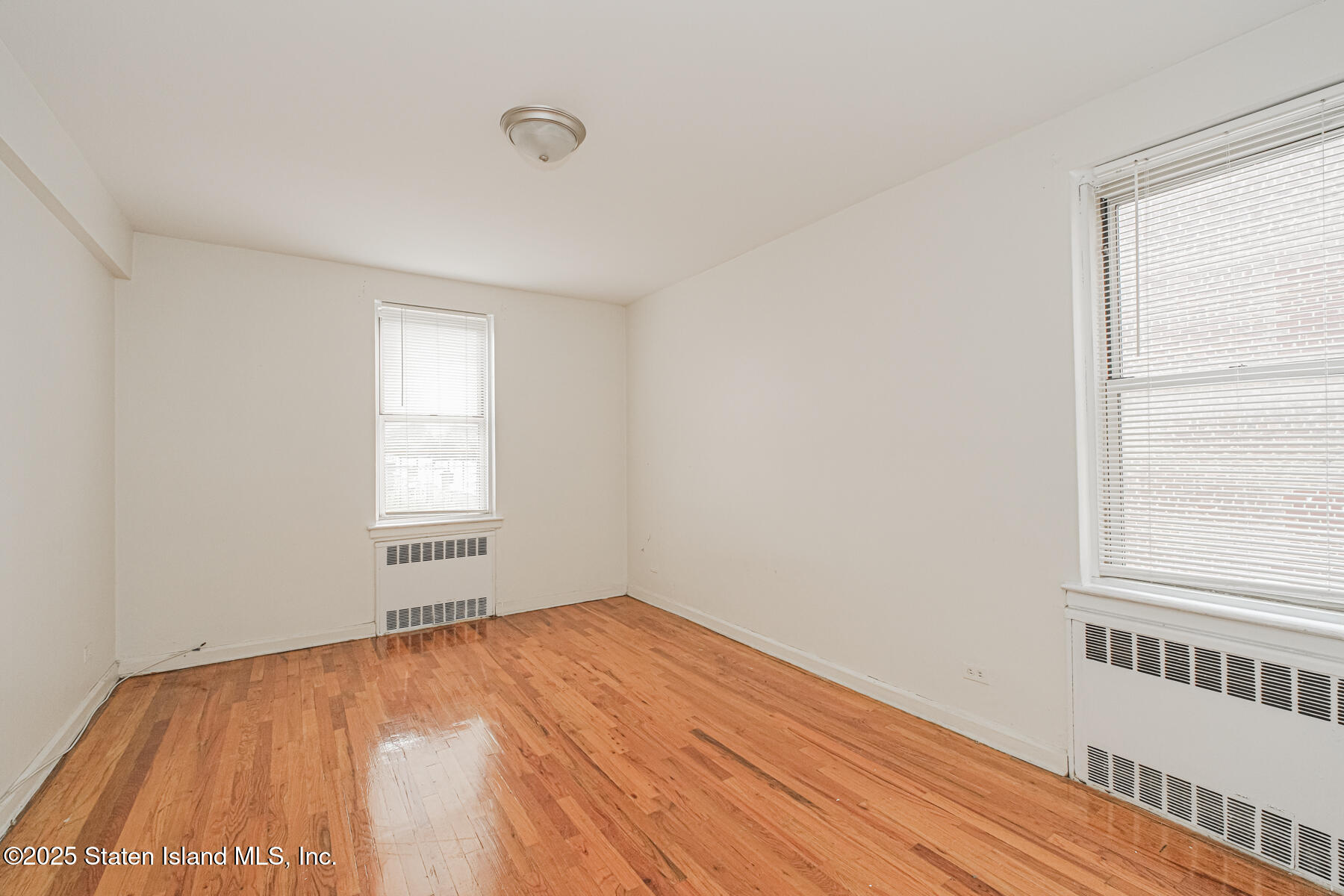 36 Dahill Road, Unit 4F Brooklyn, NY 11218 - Photo 19 of 25 an empty room with wooden floor and windows