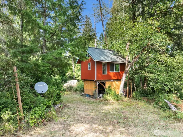 a view of a house with backyard and a tree