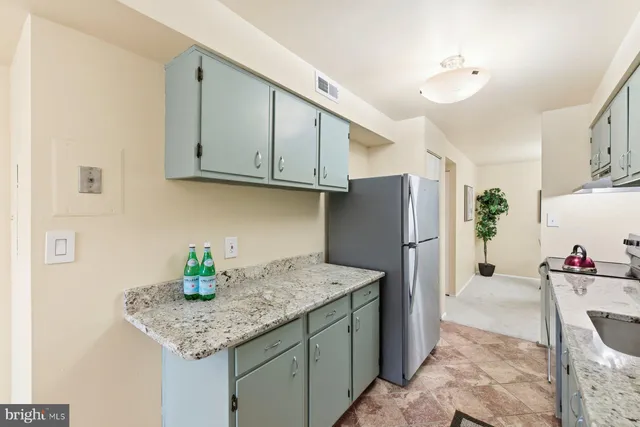 a kitchen with stainless steel appliances granite countertop a sink and a refrigerator
