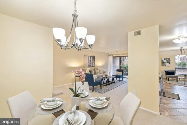 a view of a dining room with furniture a chandelier and wooden floor