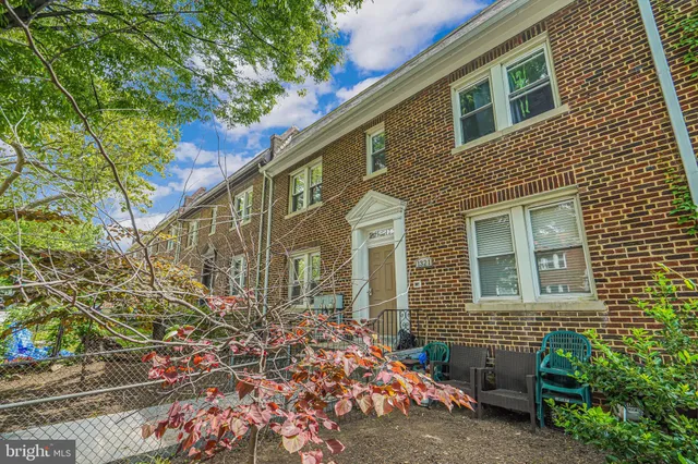 a brick building with a bench and potted plants
