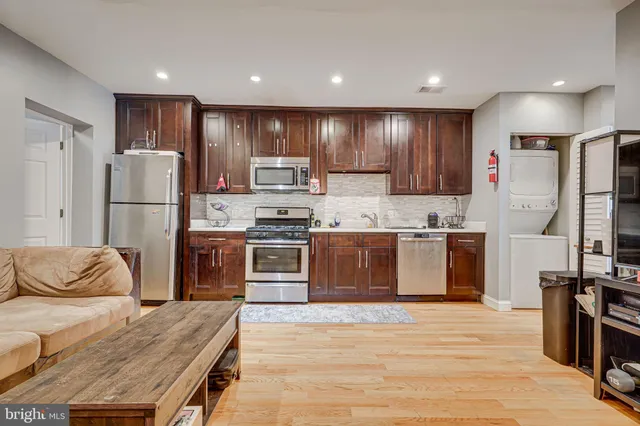 a kitchen with stainless steel appliances kitchen island granite countertop a refrigerator and a stove top oven
