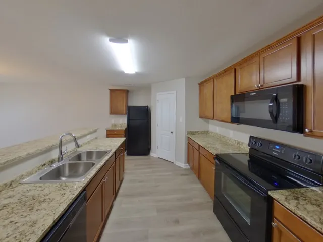 a kitchen with granite countertop stainless steel appliances and wooden cabinets