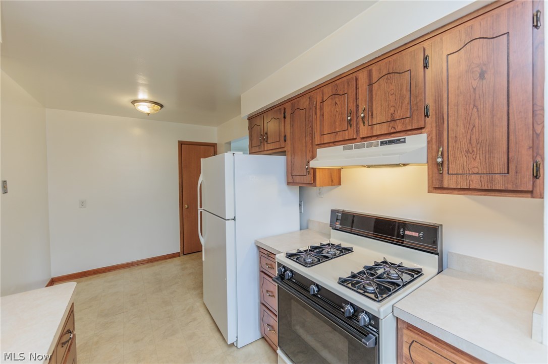 6147 Holburn Road Cleveland, OH 44129 - Photo 27 of 45 Kitchen featuring light tile patterned flooring and white appliances